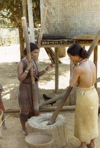 Two Nyaheun women are pounding rice in a village in Attapu Province