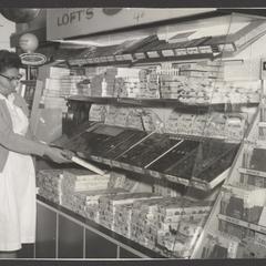 A woman examines a box of candy at a candy counter