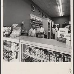 Pharmacy staff work behind the prescription counter of a drugstore