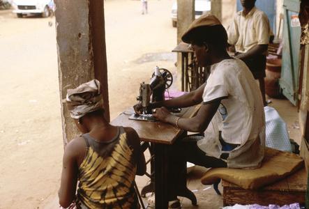 Tailor Sewing with Machine on the Street