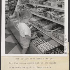 A young girl selects candy at a drugstore
