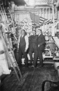 Three men in the engine room of the America