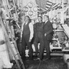 Three men in the engine room of the America