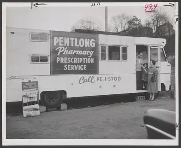 Woman stands next to a mobile pharmacy