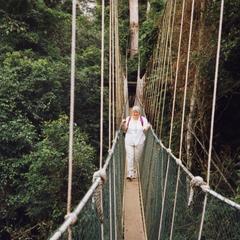 Woman walking across rope bridge in Kakum National Park