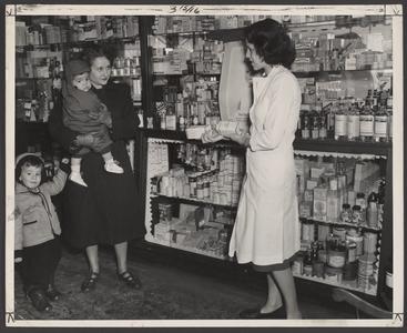 A woman speaks to a pharmacist about baby products