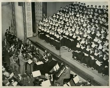 Stout Symphonic Singers, orchestra, and band members performing a concert in Harvey Hall auditorium