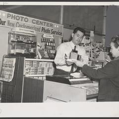 A salesman demonstrates how to use a camera for a customer