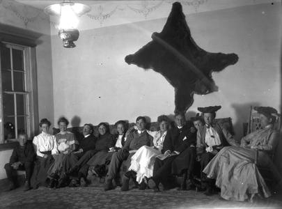 Group seated under bear skin (includes Marie and Clara Leopold)