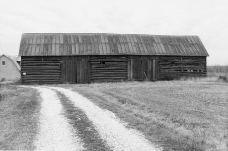 Cattle barn with collapsing perpindicular [perpendicular] addition of logs on west side (behind bldg. on photo)