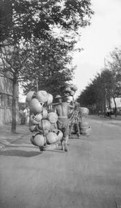 Man carrying baskets with a shoulder pole.