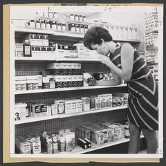 Woman looks at a product in the cough and cold section of drugstore