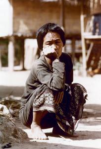 A Khmu' woman is squatting in her village in Houa Khong Province