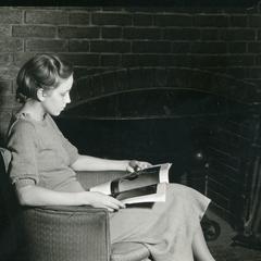 Woman reading by fireplace