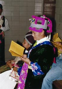 Female Hmong student reads the program at 1999 MCOR
