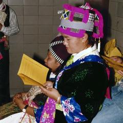 Female Hmong student reads the program at 1999 MCOR