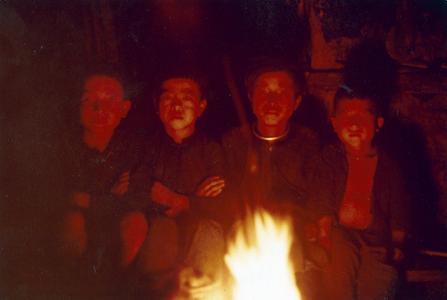 Four White Hmong boys sitting around a campfire in Houa Khong Province