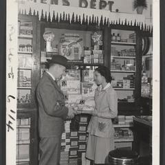 A woman helps a man in the mens department of a drugstore