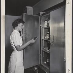 A pharmacist retrieves supplies from a refrigerated unit