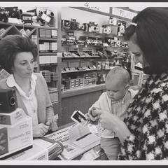 A customer views photographs in the camera department of a drugstore