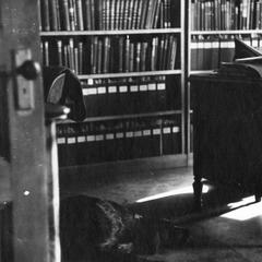 In his University office, reading, with dog "Gus" on floor, Madison, Wisconsin, ca. 1943