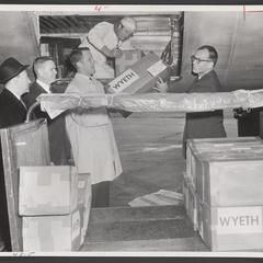 Men unload a polio vaccines from plane cargo hold