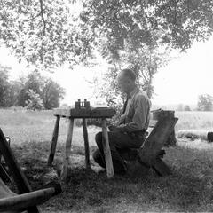 Aldo Leopold preparing journal note at the shack