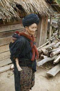 A Yao (Iu Mien) woman carries her infant in Houa Khong Province