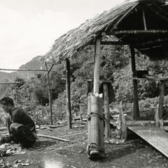 Hmong man works outside a small shelter in a Hmong village in Xaignabouri Province