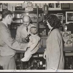 A family considers a camera purchase in a drugstore
