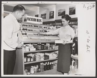 A pharmacist and saleswoman view items in a sunglass display