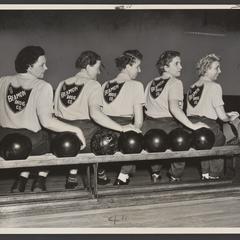 A women's drugstore bowling team poses for a group photo
