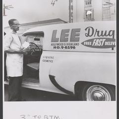 Drugstore delivery man stands next to delivery truck