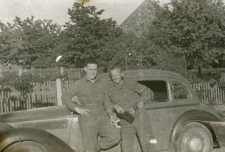 Ray Cunneen and unknown soldier pose in front of car