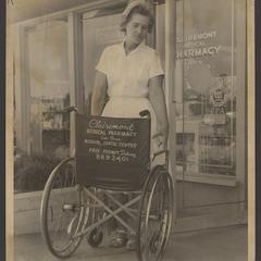 A salesclerk exhibits a wheelchair outside a pharmacy
