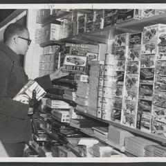 A young man looks at a model car kit in a drugstore