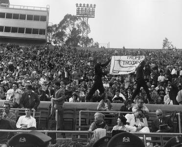 Badger fans with "Tromp Trojans" banner