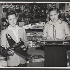 Two children hold models of a ship and an airplane