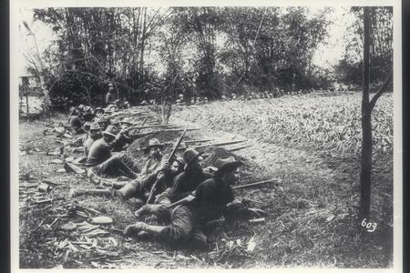 Company of American soldiers in position behind a rice dike, 1899