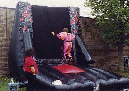 Person in a Velcro suit jumping on to an inflatable Velcro wall