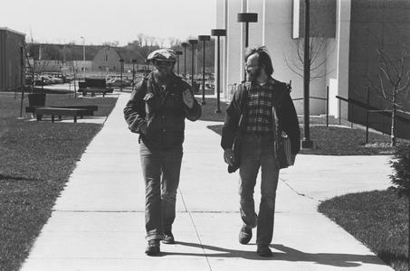 Two men walking by Laboratory Sciences building