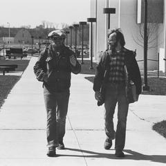 Two men walking by Laboratory Sciences building
