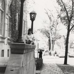 Woman reads book on ledge outside Langdon Hall