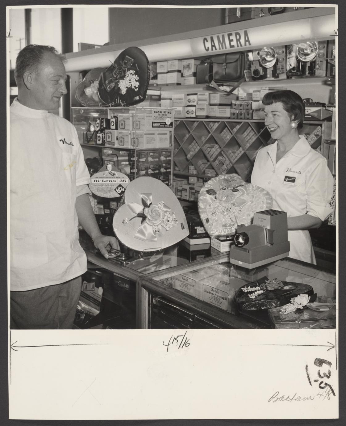 A pharmacist and a saleswoman view a Valentine's candy display