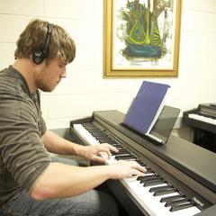 Student practices piano in music classroom