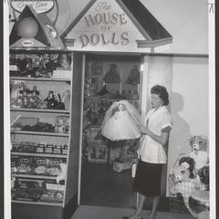 A saleswoman holds a doll at a toy display