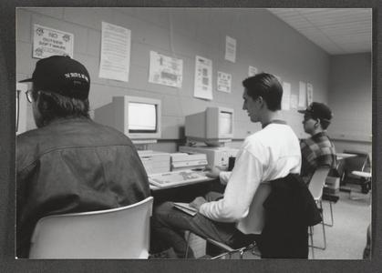 Three students in a row working in the computer lab