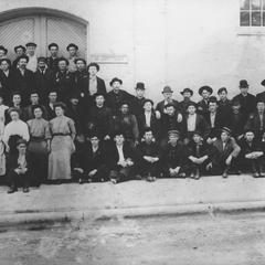 Workers posing outside unknown building