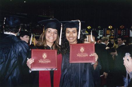 Two students show diplomas at December 2003 graduation