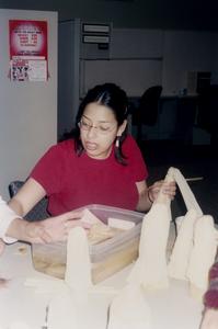 Female student making cornhusk dolls